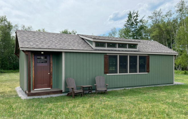 side view of a green Elite Dormer Cozy Cottage shed