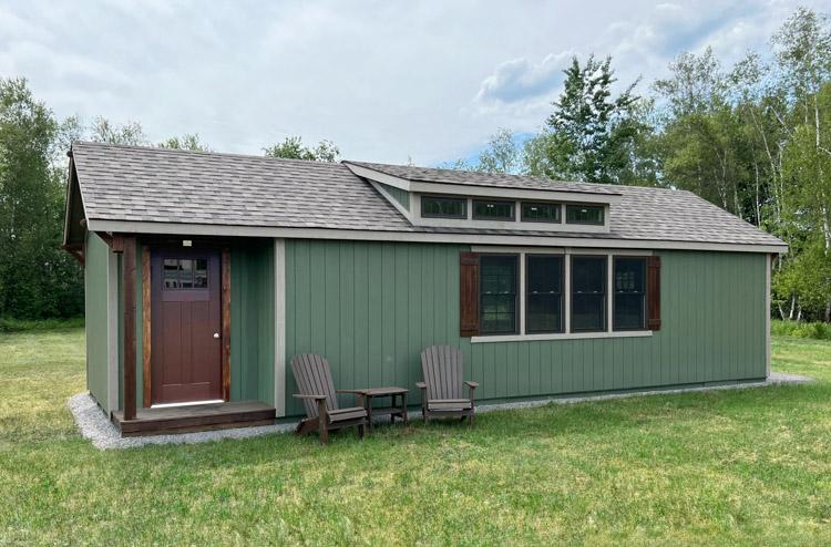 side view of a green Elite Dormer Cozy Cottage shed